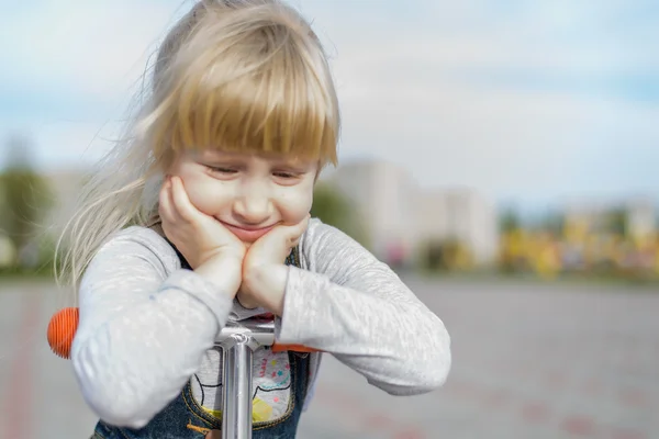 Müde nachdenkliche junge Mädchen auf einem Spielzeug-Roller — Stockfoto