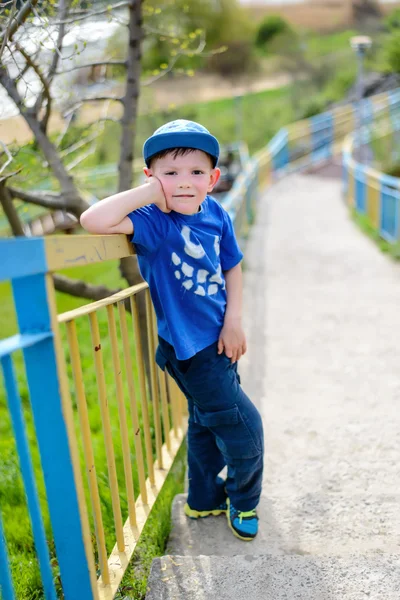 Cute boy leaning on railing outside — Stock Photo, Image