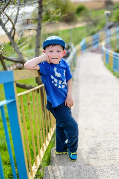 Leuke jongen leunend op de balustrade buiten — Stockfoto