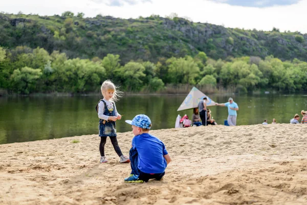 Brother and sister playing on sand near river — Stock Photo, Image