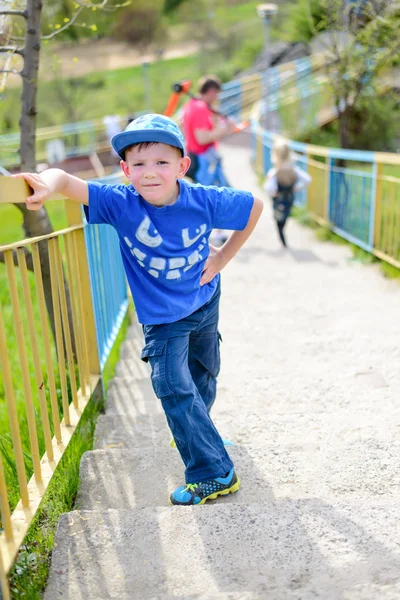 Netter Junge lehnt an Geländer draußen — Stockfoto