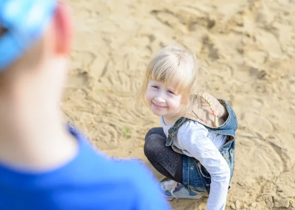 Вид сверху на ребенка, стоящего на коленях в песке — стоковое фото
