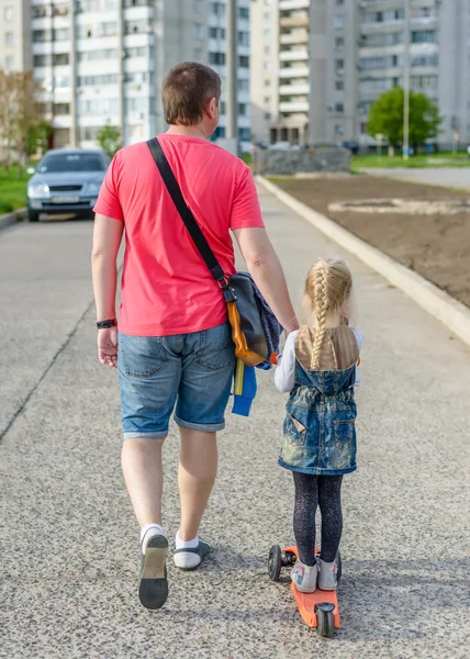 Far drar sin lilla dotter på en skoter — Stockfoto