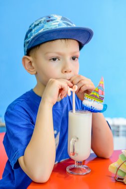 Yakışıklı trendy genç çocuk bir milkshake içme