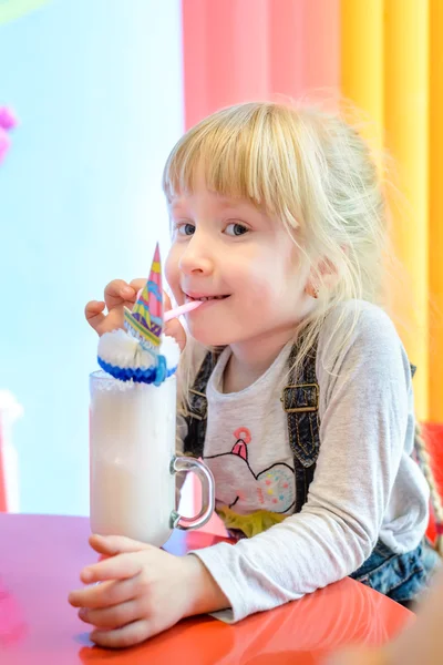 Симпатичная маленькая девочка наслаждается молочным коктейлем — стоковое фото