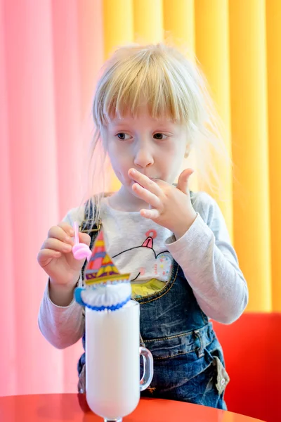 Nettes hübsches kleines Mädchen genießt einen Milchshake — Stockfoto