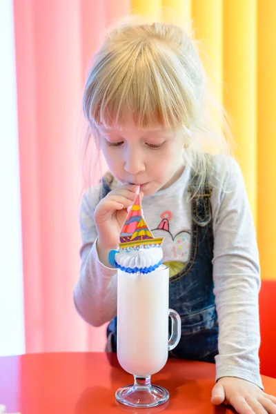 Entzückendes hübsches kleines Mädchen, das einen Milchshake trinkt — Stockfoto