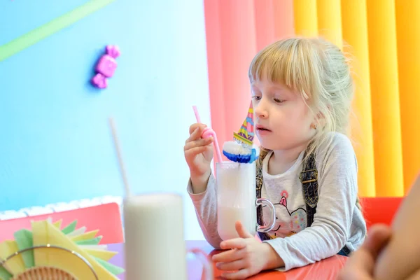 Bedårande söt liten tjej dricka en milkshake — Stockfoto