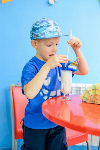 Trendiga glada lilla pojken njuter en milkshake — Stockfoto