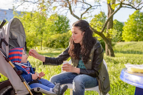 Junge Mutter füttert ihren kleinen Sohn — Stockfoto