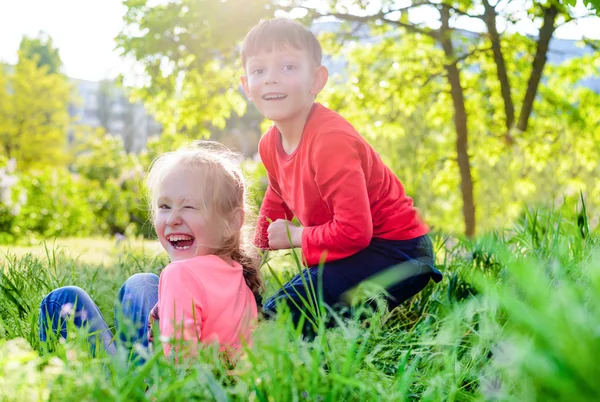 Bir bahçede oynayan iki mutlu gülen çocuklar — Stok fotoğraf