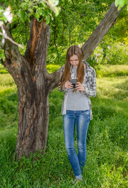 Lange slanke jong meisje haar mobiele controleren — Stockfoto