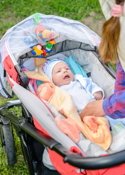 Mutter kümmert sich um ein winziges Baby im Kinderwagen — Stockfoto