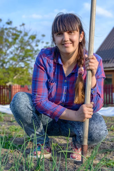 Middelbare leeftijd vrouwelijke gardner leunend op haar rake — Stockfoto