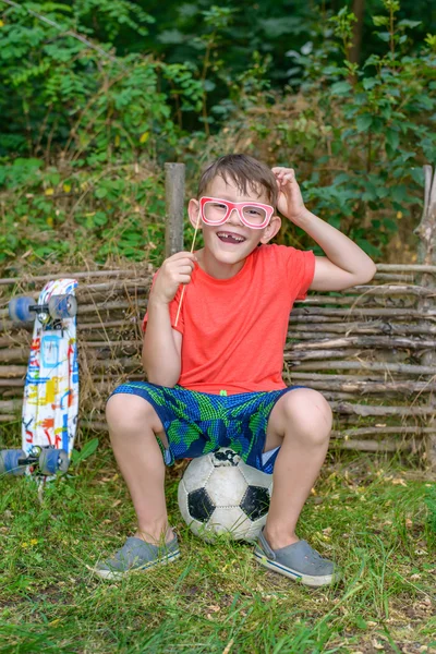 Funny young boy playing with photo booth props — Stock Photo, Image