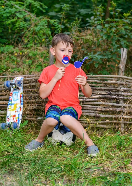 Мальчик держит игрушечную трубку и шутливые символы у рта — стоковое фото