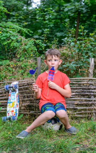 Piccolo ragazzo che gioca con gli oggetti di scena della cabina fotografica — Foto Stock