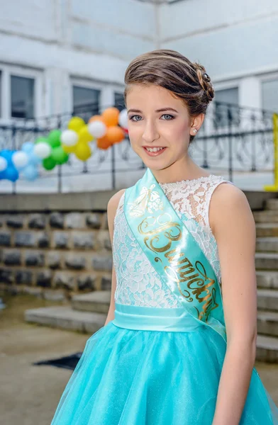 Girl in blue beauty pageant dress near balloons