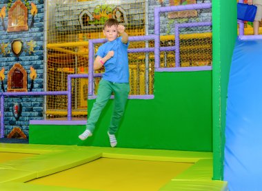 Bir Trambolinde zıplayan coşkulu genç çocuk
