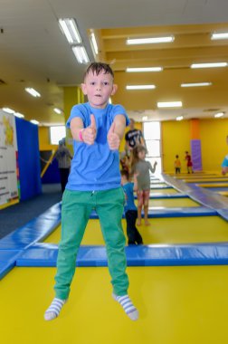 Mutlu küçük çocuk bir Trambolinde zıplayan