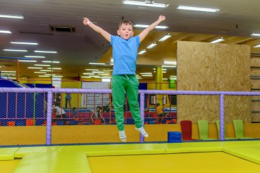 Mutlu küçük çocuk bir Trambolinde zıplayan