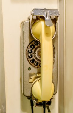 Eski döner telefon duvara monte edilmiş sarı