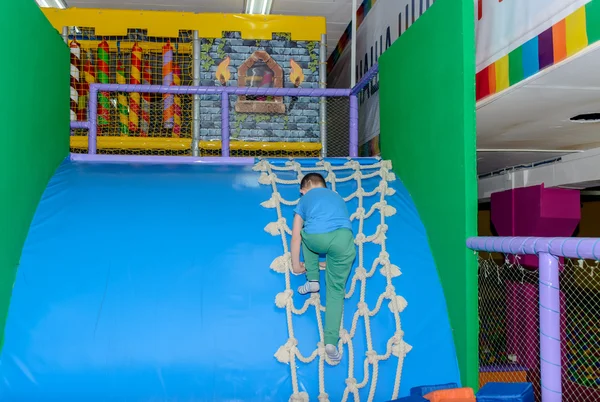 Little boy sliding down a curved plastic slide — Stock Photo, Image