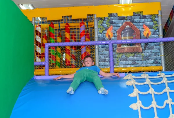 Liten pojke glida ner en böjd plast slide — Stockfoto