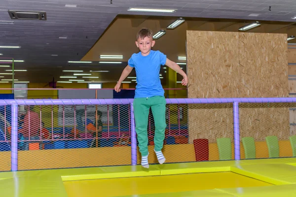 Sprudlande ung pojke studsande på en studsmatta — Stockfoto