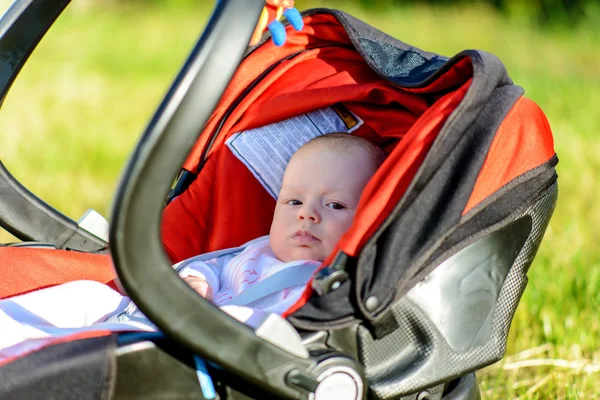 Adorable little baby asleep in a carry cot — Stock Photo, Image