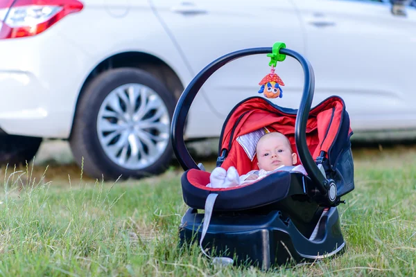 Lieve kleine baby rust buitenshuis in een reiswieg — Stockfoto