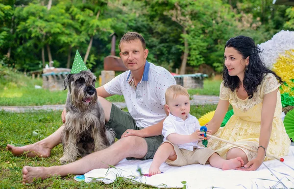 Familie tânără fericită în parc cu câinele lor — Fotografie, imagine de stoc
