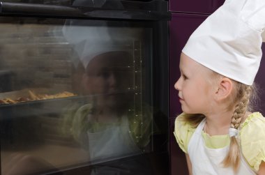 fırın içine yiyecek arayan chef şapka giyen kız