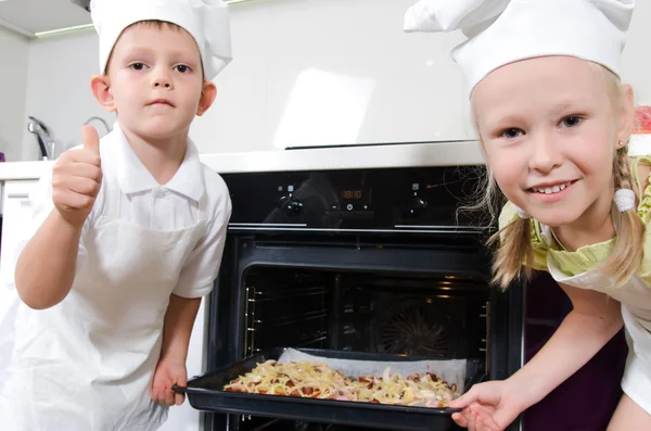 Happy excited young children with homemade pizza — Stock Photo, Image