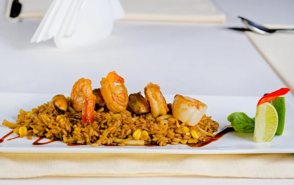 Hlavní jídlo rizoto s krevetami na bílé desce — Stock fotografie