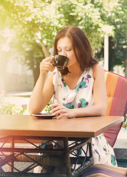 Kobieta pije kawę w kawiarni na świeżym powietrzu — Zdjęcie stockowe