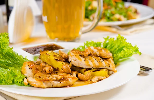 Mok van bier op Restaurant tafel met vergulde voedsel — Stockfoto