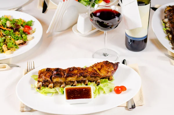 Copa de vino servido con costillas en el restaurante —  Fotos de Stock