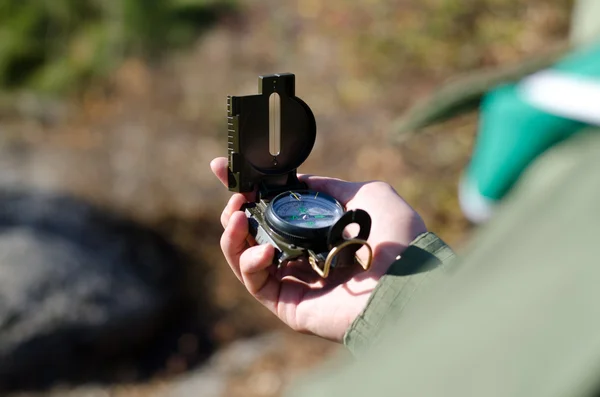 Explorer consulting a classical handheld compass — Stock Photo, Image