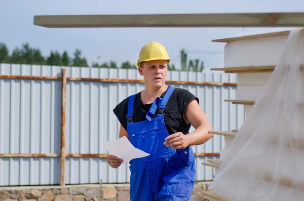 Bezorgd bouwer op site met een document — Stockfoto