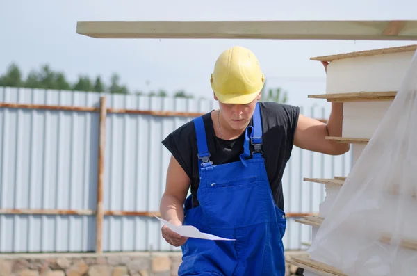 Worried builder on site with a document — Stock Photo, Image