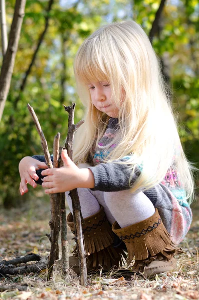 Menina bonito brincando com paus secos — Fotografia de Stock