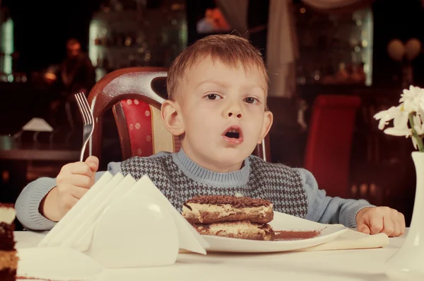 Lindo niño a punto de meter en una rebanada de pastel — Foto de Stock