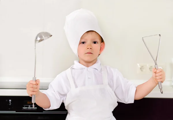 Proud little boy chef in a white toque — Stock Photo, Image