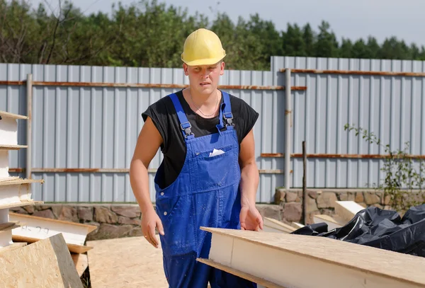 Builder carrying an insulated wooden wall panel — Stock Photo, Image