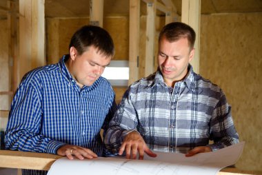 İki inşaatçılar yapı planı tartışıyor
