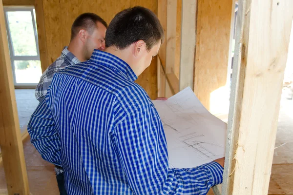 Two carpenters or builders discussing a plan — Stock Photo, Image