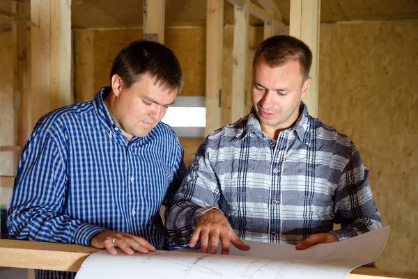 Twee bouwers bespreken een bouwtekening — Stockfoto