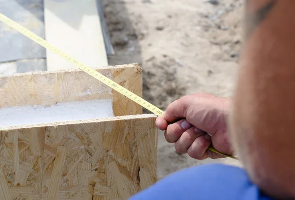 Builder taking a measurement — Stock Photo, Image