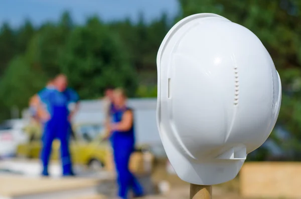 Hardhat on a pole at a building site — Stock Photo, Image